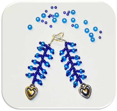 Zweigförmige blaue Rocailles-Ohrringe mit herzförmigen Metallanhängern auf hellem Hintergrund