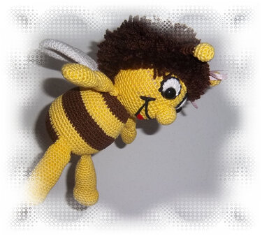 Gehäkelte Amigurumi-Biene, gelb-braun gestreift mit weißen Flügeln und braunem Haar