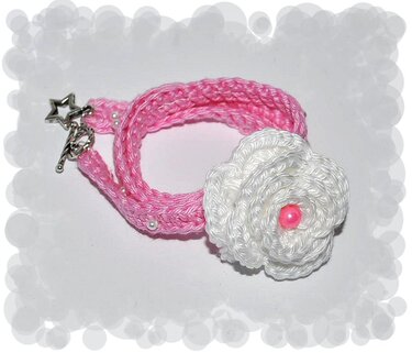 Rosa gehäkeltes Armband mit weißer Blüte, pinker Perle und sternförmigem Knebelverschluss
