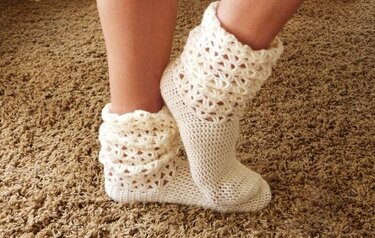 Cremefarbene Häkel-Socken mit enganliegendem Fußteil und weitem ajourierten Bündchen