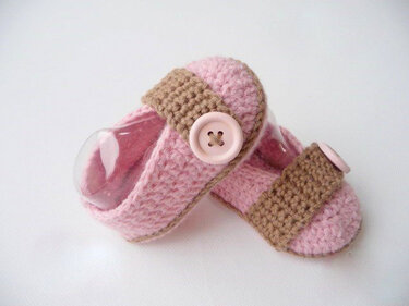rosa gehäkelte Baby-Ballerinas mit braunem Riemen und rosa Knopf