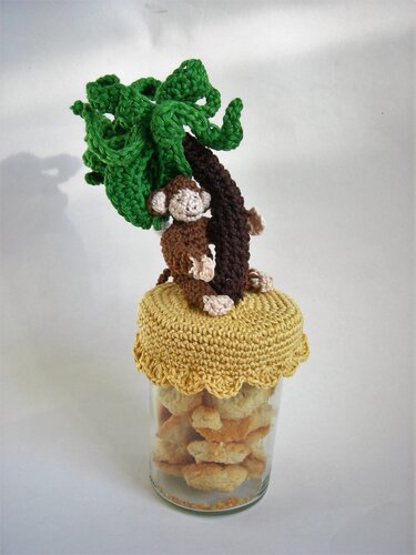Gehäkelter Affe und Palme als Deckelaufsatz auf einem Vorratsglas mit Gebäck