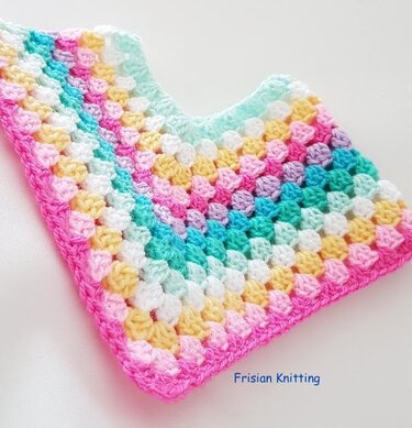 Pastel granny square crochet poncho with a V-neckline, rows of pink, yellow, mint, teal, and white, edged in bright pink.