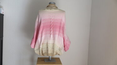 Rückansicht eines gestrickten Seelenwärmers in Rosa und Beige mit mittigem Zopf und Lochsaum auf Büste