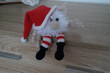Gehäkelter Weihnachtswichtel mit roter Zipfelmütze, flauschigem Bart und gestreiften Beinen