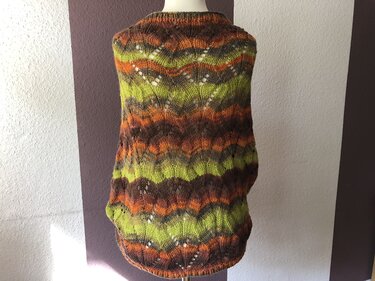 Rückansicht gestrickter Seelenwärmer in Grün, Orange und Braun mit welligem Lochmuster