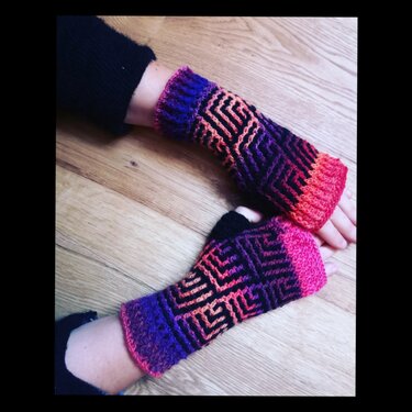Fingerlose Häkelhandschuhe in Violett, Pink und Orange mit schwarzem Muster und sichtbarer Daumenöffnung