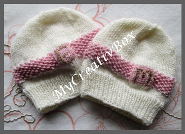 Zwei gestrickte weiße Babymützen mit rosa Zierband