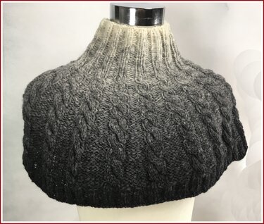 Kurzcape-Loop mit hohem Rippenkragen und vertikalen Zopfreihen, Ombré von Creme zu Anthrazit