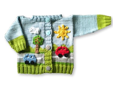 Hellblaue gestrickte Babyjacke mit grünen Bündchen und Applikationen: rote und blaue Autos, gelbe Sonne, Baum und Wolke