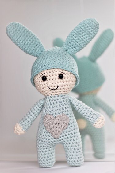 Gehäkelter Amigurumi-Hase in Hellblau mit langen Ohren und grauem Herz auf der Brust.