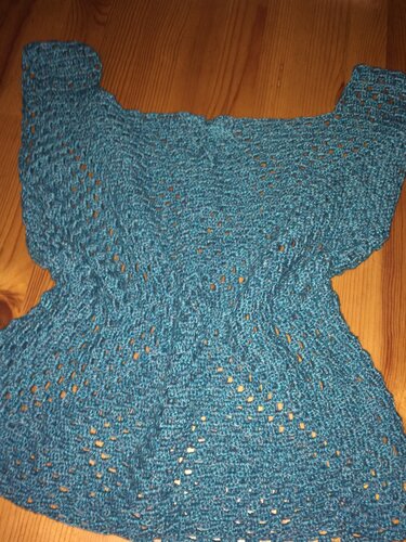 Petrolfarbenes gehäkeltes Damen-Top mit Ajourmuster auf Holzboden.