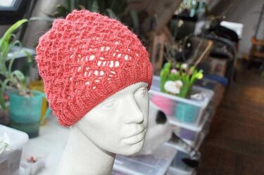 Korallfarbene, offen gestrickte Slouch-Mütze auf Mannequin