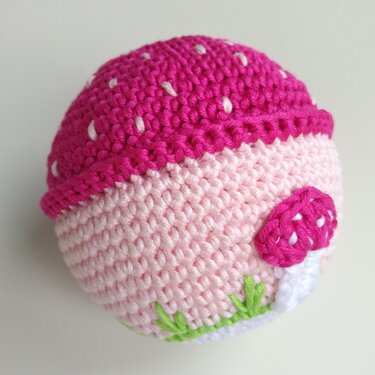 Rosa gehäkelter Babyspielball mit Pilzapplikation