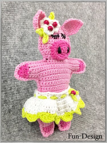 Gehäkeltes rosa Schweinchen-Amigurumi mit weiß-gelbem Rock, Blüte und Perlen