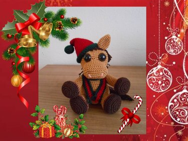 Niedliches gehäkeltes Amigurumi-Pony mit rot-grüner Weihnachtsmütze und großen Augen in einem dekorativen roten Rahmen