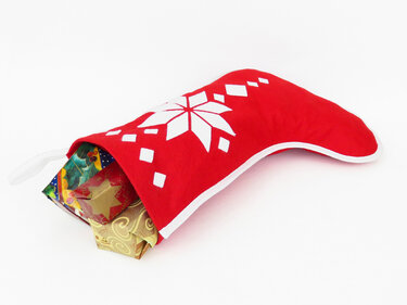 Roter Weihnachtsstrumpf mit weißem Sternenmuster, gefüllt mit kleinen, festlich verpackten Geschenken