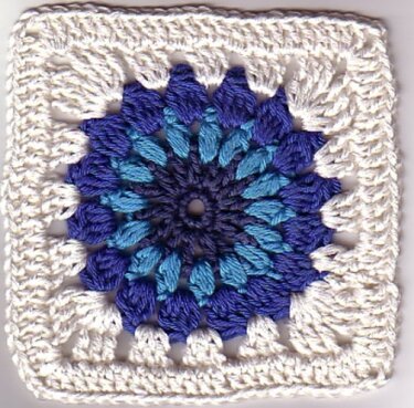 Quadratisches Häkelmotiv mit blauem Sternmuster und weißer Umrandung