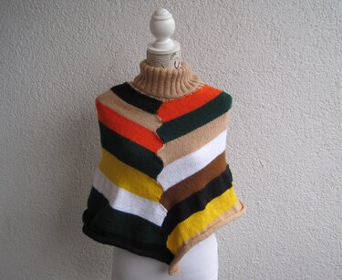 Strickponcho mit diagonalen bunten Streifen und beigem Rollkragen auf Schaufensterpuppe