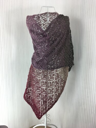 Gestrickter Ombré-Schal in Dunkellila zu Weinrot mit filigranem Lochmuster, drapiert auf einer Schneiderpuppe.
