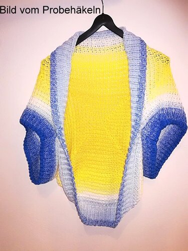 Gehäkelte offene Jacke in Gelb mit blauen Ärmeln und breitem Revers, an schwarzem Kleiderbügel