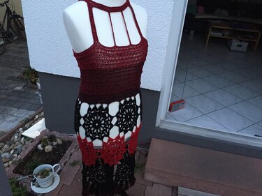 Gehäkeltes Rot‑Schwarz Kleid auf Schaufensterpuppe mit Neckholder‑Oberteil und Mandala‑Lochmuster im Rock