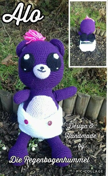 Lila gehäkelter Amigurumi-Bär mit weißer Windel, großen schwarzen Augen und pinkem Haarbüschel, sitzend im Garten