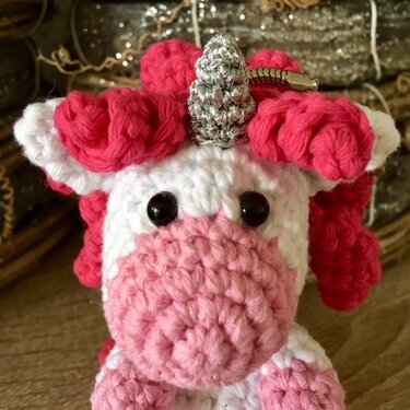 Gehäkelter Einhornkopf Amigurumi in Weiß und Rosa mit pinker Lockenmähne und silbernem Horn, mit Metallclip