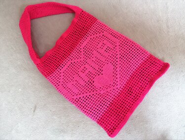Gehäkelte Tasche in Pink mit Netzmuster und Herzmotiv
