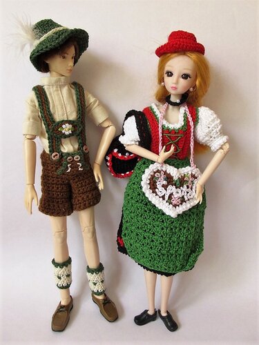 Zwei Puppen in gehäkelter Tracht, eine mit Lederhose, eine im Dirndl