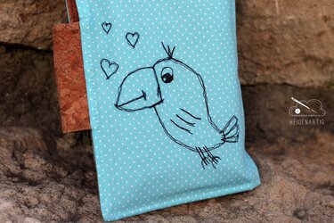 Hellblaue Tasche mit weißen Punkten, gesticktem Vogelmotiv und Herzen, Korkstoff-Akzent an der Seite.