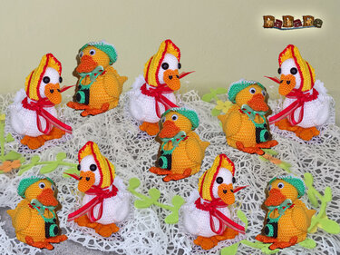 Neun gehäkelte Amigurumi-Enten und Küken mit Mützen, Schleifen und Mini-Kameras