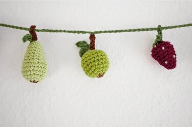 Handgehäkelte Obstgirlande mit Birne, Apfel und Erdbeere an grüner Kordel