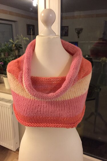 Gestrickter Loop-Schal in Korall-, Rosa- und Cremetönen auf Schneiderbüste mit umgeschlagenem Rollkragen