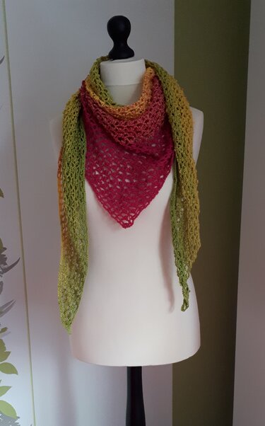 Gehäkeltes Dreieckstuch in Grün, Gelb und Pink auf Schneiderpuppe, offenes Netzmuster