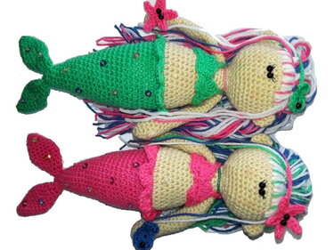 Zwei gehäkelte Meerjungfrauen-Amigurumi (grün und pink) mit mehrfarbigen Garnhaaren und Perlenakzenten auf weißem Hintergrund.