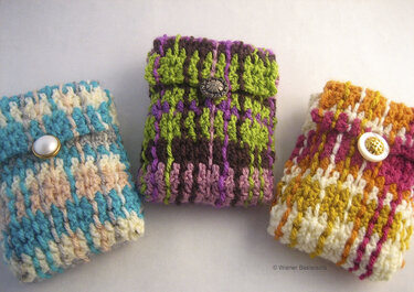 Drei gehäkelte Mini-Täschchen in Türkis, Grün/Violett und Gelb/Pink mit Umschlag und Knopf