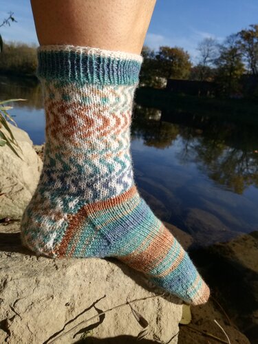 Nahaufnahme einer gestrickten Socke mit Bündchen, Ferse und gemustertem Schaft
