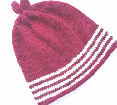 Glatt rechts gestrickte Babymütze mit weißen Streifen und Knoten