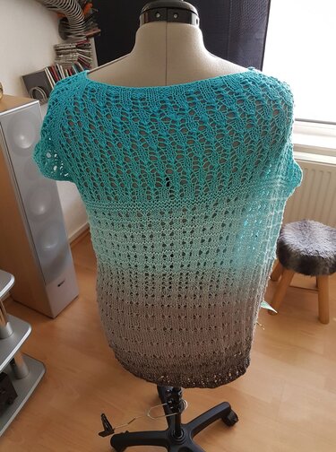 Rückenansicht gestrickter Kurzarm-Tunika in Türkis-Grau mit offenem Lochmuster auf Schneiderpuppe