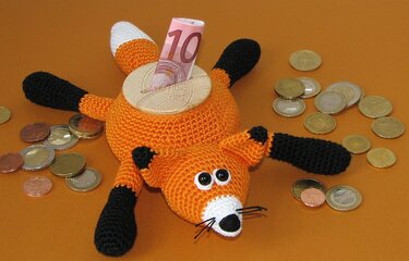 Gehäkelte orange-weiße Fuchs-Spardose mit Holzdeckel und Geldschein