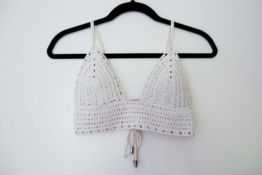 Weißes gehäkeltes Top mit Triangelcups und Bindeband an schwarzem Bügel