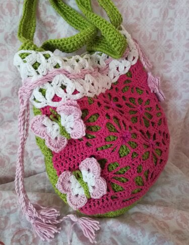 Gehäkelte Henkeltasche in Rosa, Grün und Weiß mit Lochmuster, Schmetterlings-Applikationen und Kordelzug