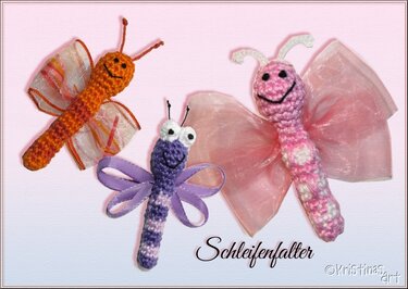 Drei gehäkelte Amigurumi-Insekten: orangefarbener Schmetterling, lilafarbene Libelle und pinker Schmetterling mit Schleifenflügeln und lachenden Gesichtern.