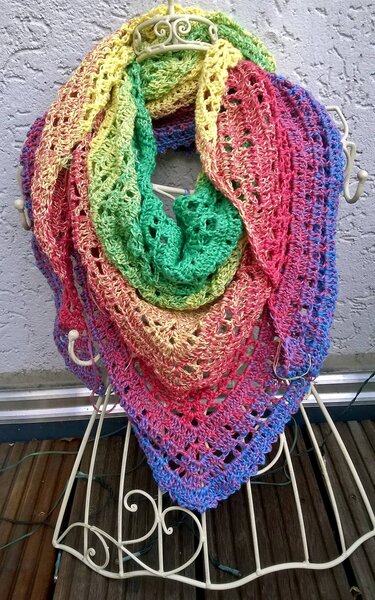 Buntes gehäkeltes Dreieckstuch in Regenbogenfarben mit Lochmuster auf weißem Ständer