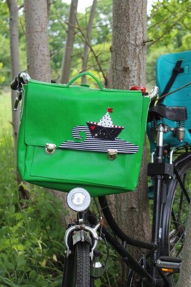 Leuchtend grüne Lenkertasche mit Schiff-Applikation und zwei Steckverschlüssen am Fahrradlenker