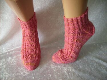 Kurzschaftige rosa Damensocken mit Zopfreihen und Ajourpunkten auf Mannequin-Füßen