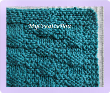 Quadratischer tcrkiser, gestrickter Topflappen mit Zopfmuster und Strukturstreifen