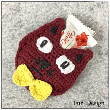 Dunkelrote gehäkelte Eule mit weißen Augen und gelber Schleife