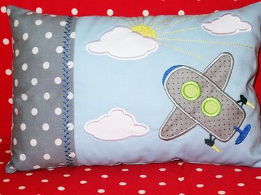 Appliziertes Flugzeug mit gestickten Konturen und Wolken auf Kissen